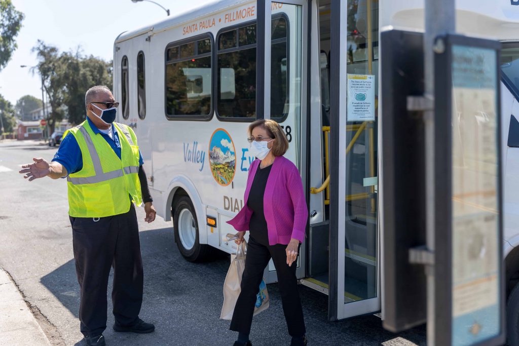 Driver helping woman off bus