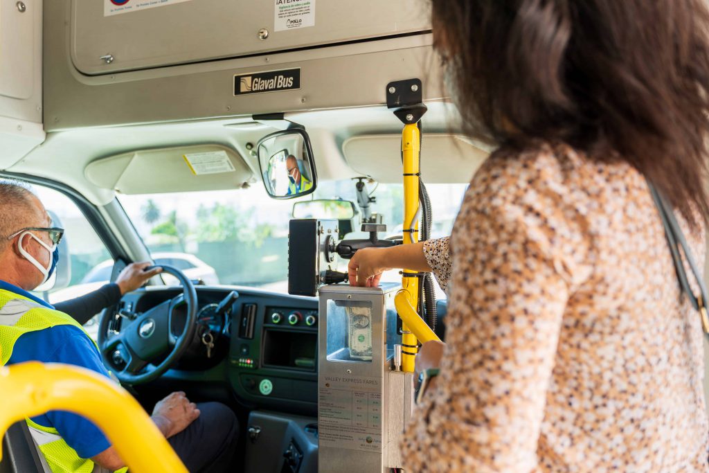 Woman adding cash payment to fare box